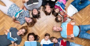 Mitglieder des BuchQuartiers liegen im Kreis am Boden und lachen