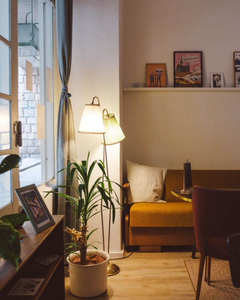 Gemütliche Sitzecke mit Sofa, Pflanzen und warmen Leuchten im Café des BuchQuartiers